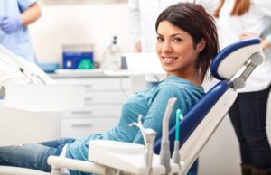 Young female patient sitting on chair in dental office.preparing for dental exam.Looking at camera.